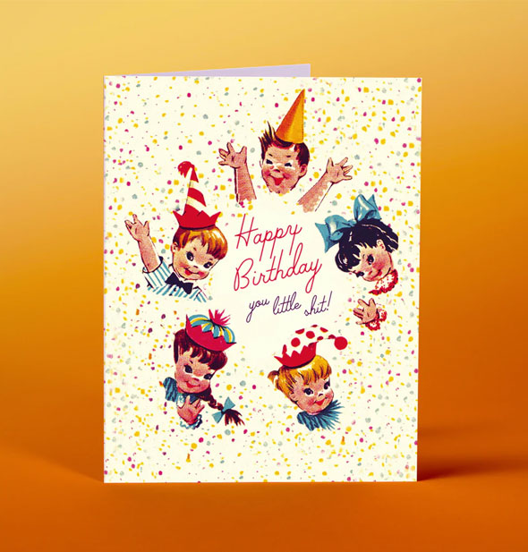 Greeting card with vintage-style illustration of children in party hats surrounded by confetti says, "Happy birthday you little shit!"