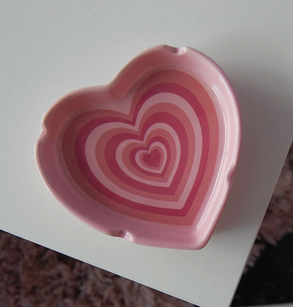 Pink heart shaped ashtray on a white surface