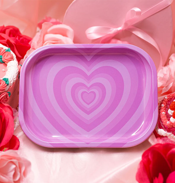 Rectangular tray with rounded corners features a repeating pink heart design radiating from the center