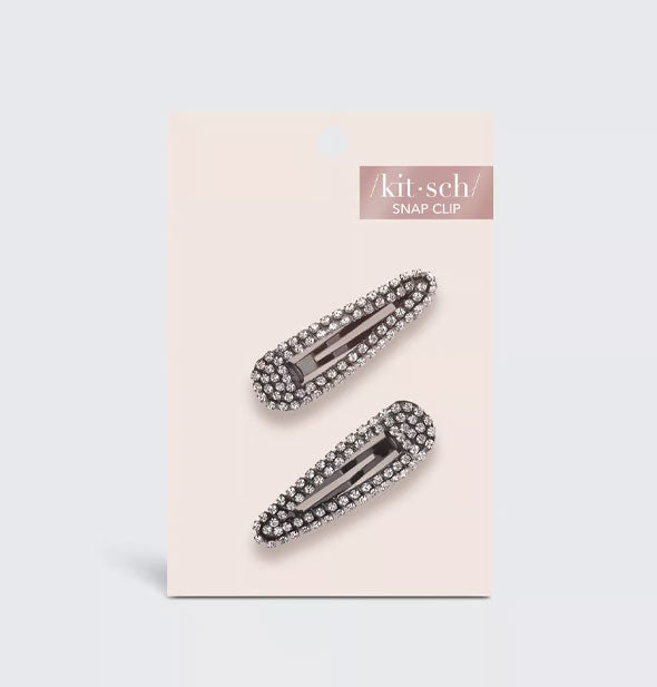 Two rhinestone-encrusted hematite snap clips on a light pink Kitsch product card