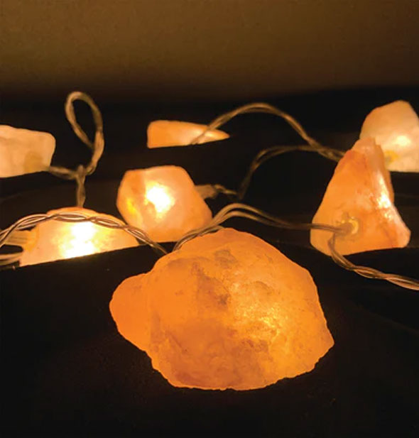 Salt crystal string lights are lit from within against a dark background