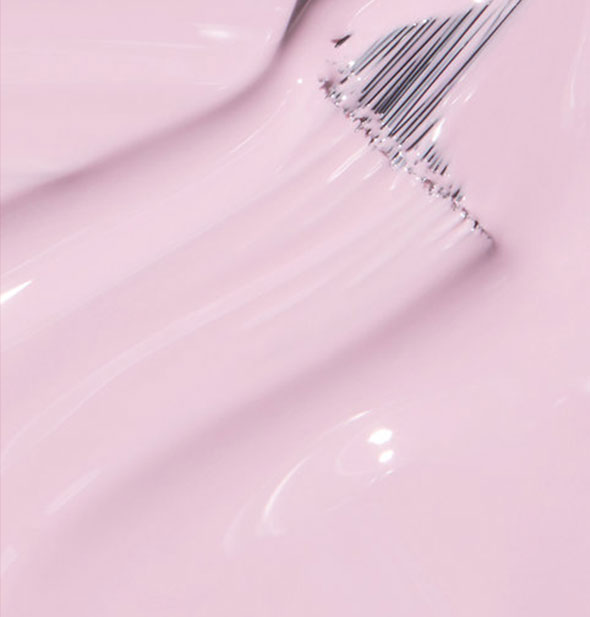 Pastel pink nail polish with brush tip drawn through it