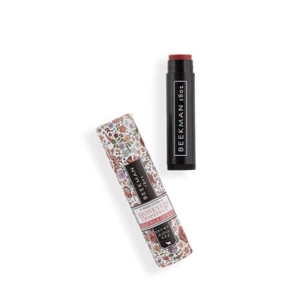 Black tube of Honeyed Grapefruit tinted lip balm by Beekman 1802 with decorative floral packaging