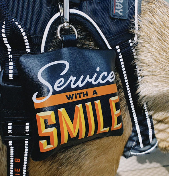 Service With a Smile waste bag holder is attached to a dog's harness