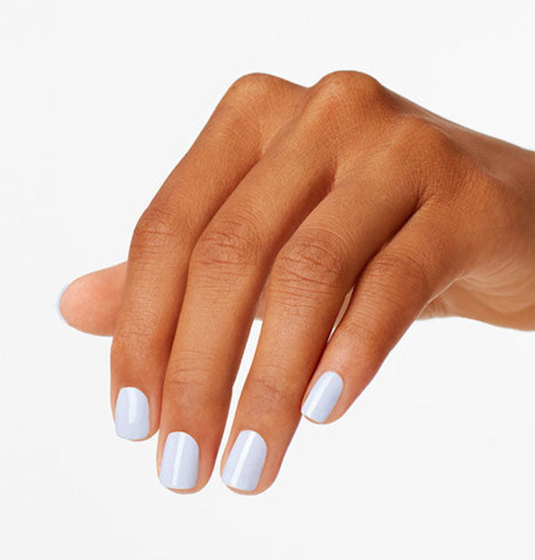 Model's hand wears a very light blue shade of nail polish
