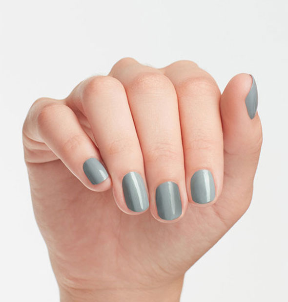 Model's hand wears a shade of greenish-gray nail polish