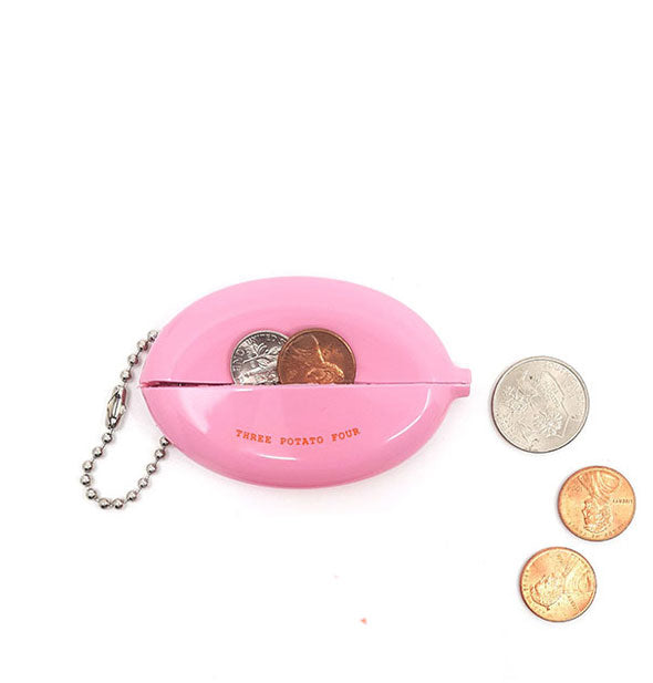 Pink rubber change purse reverse side shows pinch-open slot for coins