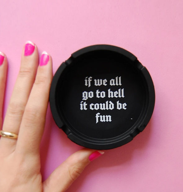 Model's hand touches the If We All Go to Hell It Could Be Fun ashtray for size reference