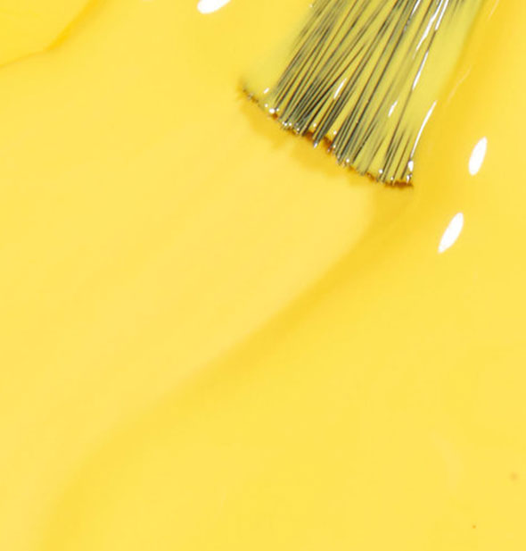 Bright yellow nail polish with brush tip applied