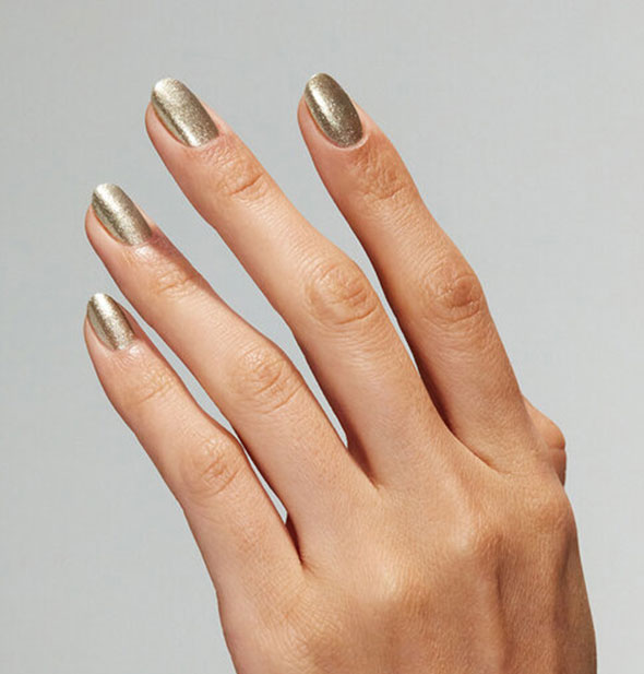 Model's hand wears a shimmery gold shade of nail polish