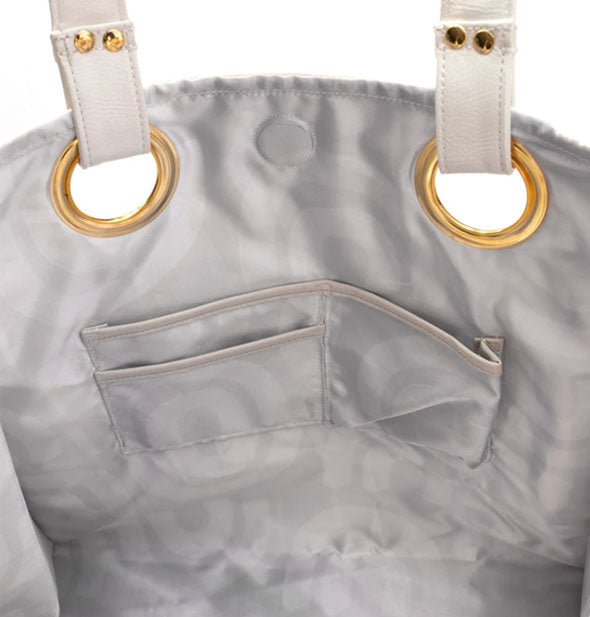 Tote bag interior with silver lining, slip pockets, and gold handle hardware