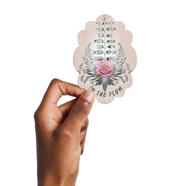 Model's hand holds the In the Flow rose sticker