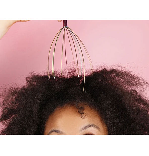 Model demonstrates use of the Iridescent Head Massager