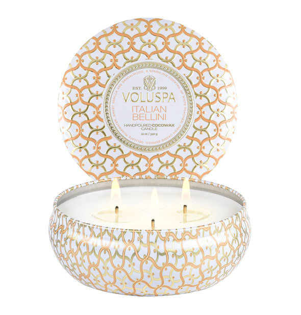 Orange and white patterned Voluspa Italian Bellini candle tin with three lit wicks