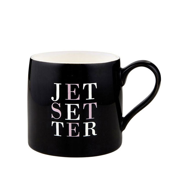 Black coffee mug with white interior says, "Jetsetter" split up onto three lines in minimalist pink and white lettering