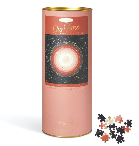 Cylindrical pink Jig Time Jigsaw Puzzle container with celestial motif and several puzzle pieces set to the side
