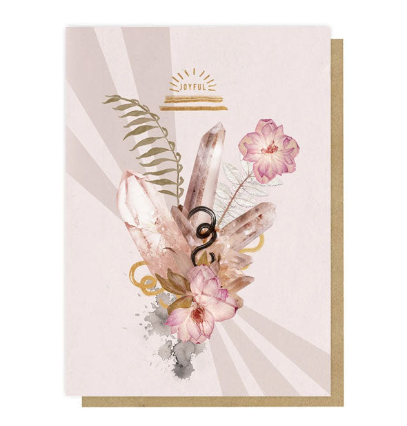 Light pink greeting card with kraft envelope behind features illustrated flowers, leaves, and crystals below the word, "Joyful" accented in metallic gold foil