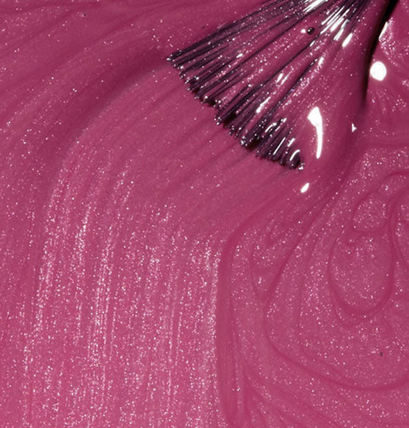 Shimmery pink-purple nail polish with a brush tip streaked through it