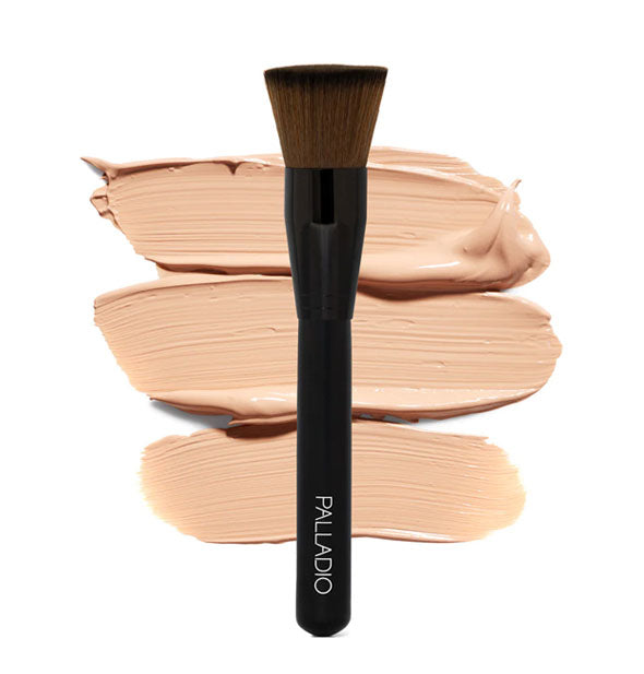 Black palladio makeup brush in front of sample liquid makeup swatches features a flat-topped bristle shape