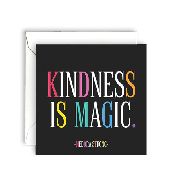 Square black greeting card with white envelope is printed in white lettering with colorful accent letters with a quote by Medora Strong: "Kindness is magic."