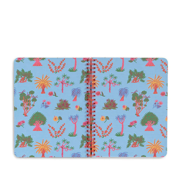 Open notebook with red spiral-bound colorfully illustrated pages with tree motif on blue background