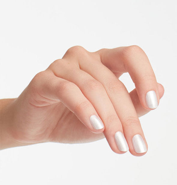 Model's hand wears a shade of pearlescent silver-white nail polish
