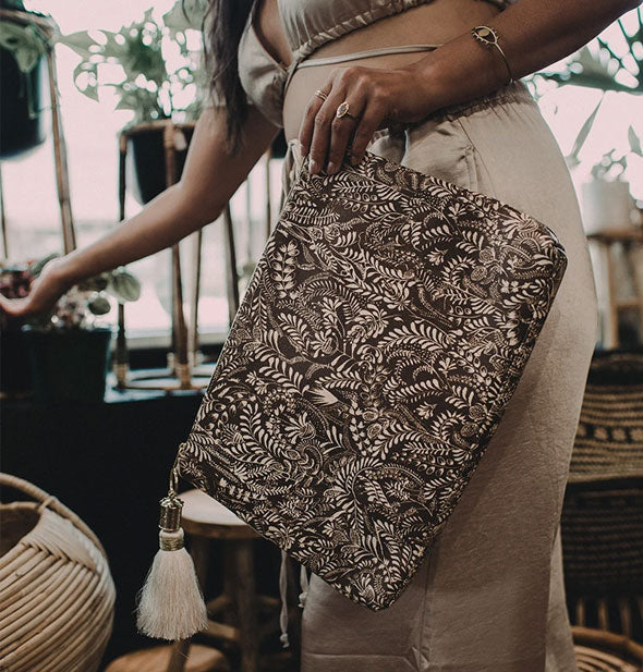 Model holds a large floral pouch with tassel attached
