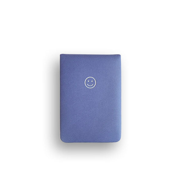 Blueish-purple notepad cover with white stamped smiley face near top center