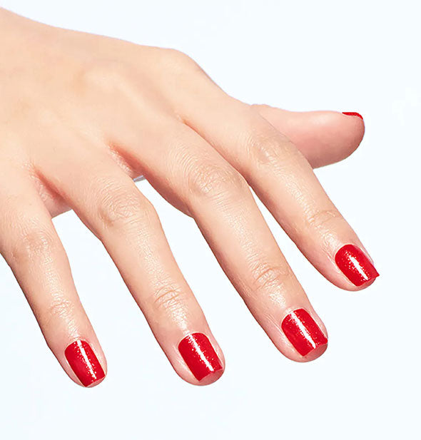 Model's hand wears a bright, shimmery shade of nail polish