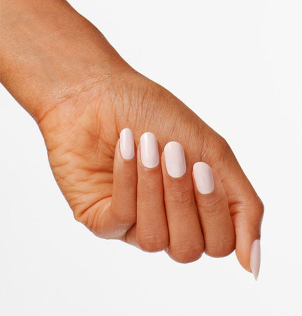 Model's hand wears a white-pink shade of nail polish