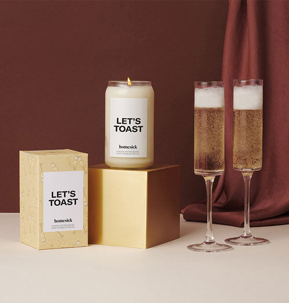 Let's toast candle and box with two glasses of champagne