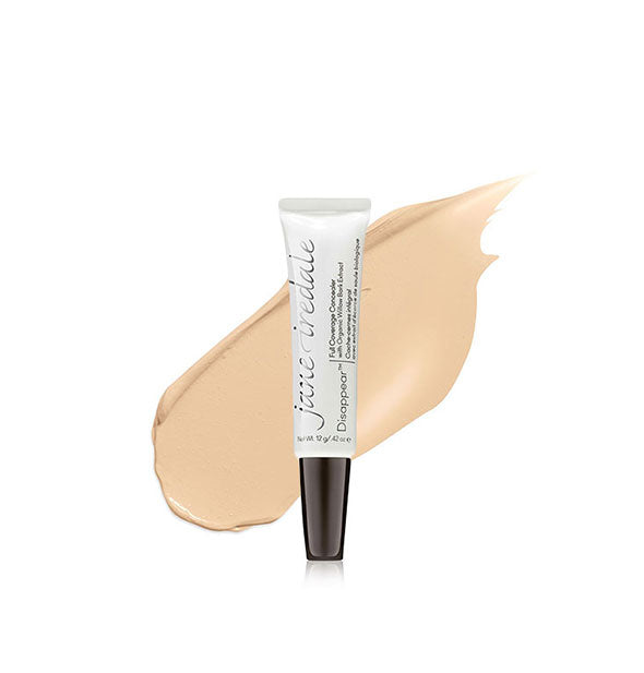 Tube of Jane Iredale Disappear Full Coverage Concealer with color swatch behind in the shade Light