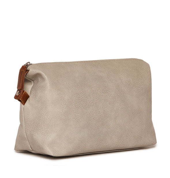 A textured vegan leather dopp cosmetic bag in a light brown/taupe color with brown zipper pull.