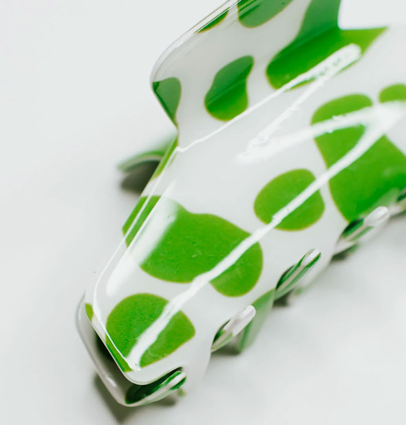 Closeup of white hair clip with lime green cow print spots