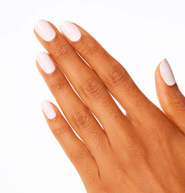 Model's hand wears an almost-white pink shade of nail polish