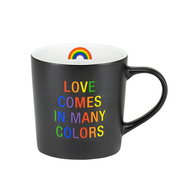 Black coffee mug with white interior featuring rainbow graphic says, "Love comes in many colors" in multicolor lettering