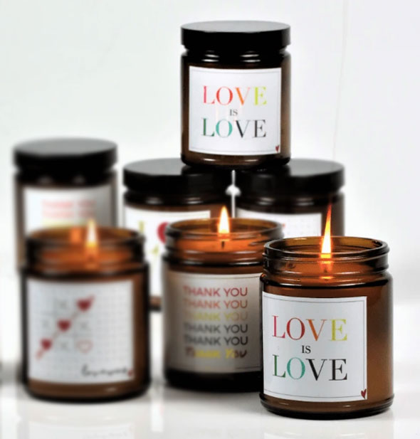 An arrangement of amber glass candles with love-themed labels