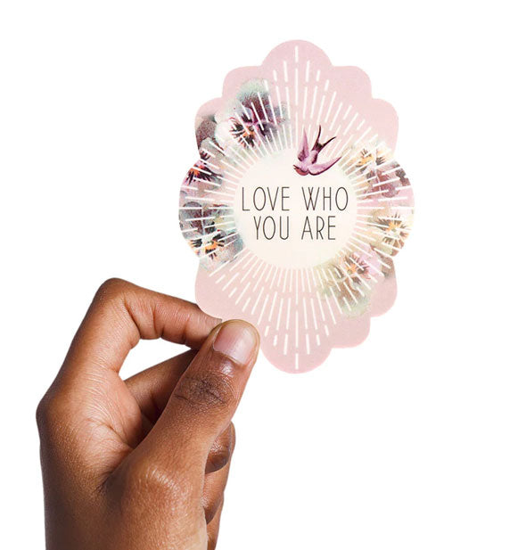 Model's hand holds a 4-inch tall Love Who You Are sticker for size reference