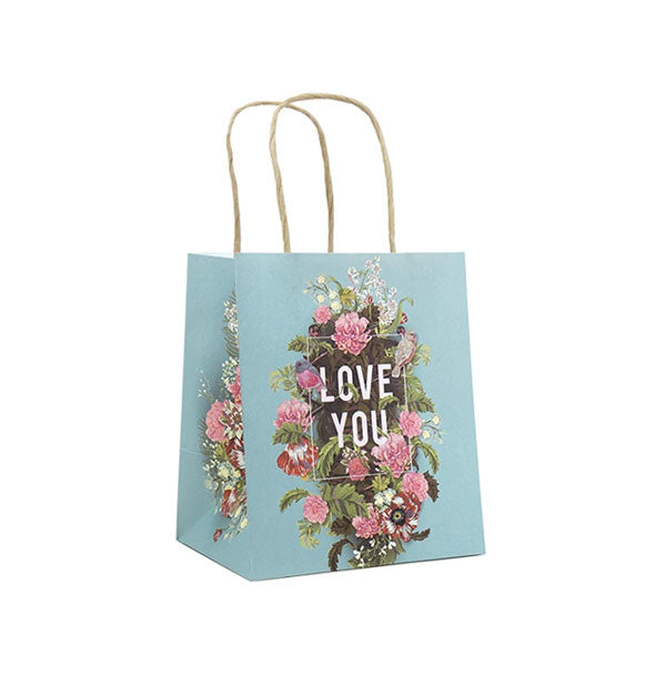 Small blue gift bag says, "Love you" inside a lush floral bouquet design