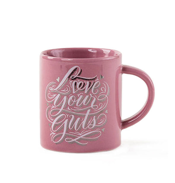 Pink coffee mug says, "Love your guts" in ornate white script with decorative flourishes