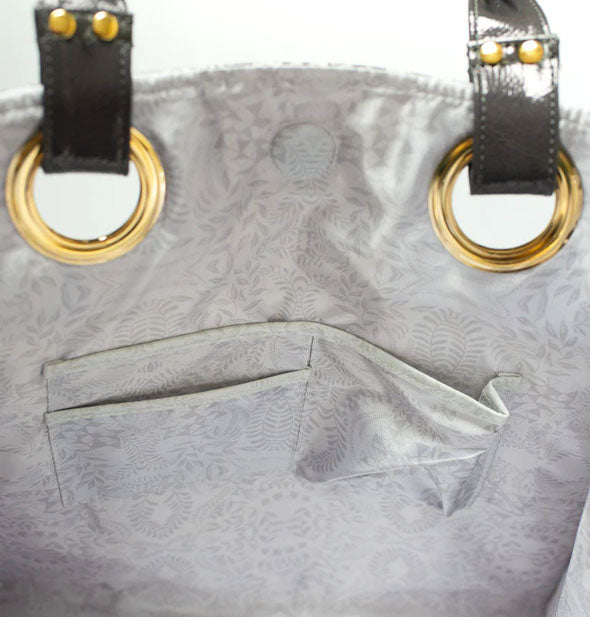 Tote bag interior with gray patterned lining, slip pockets, and gold handle hardware