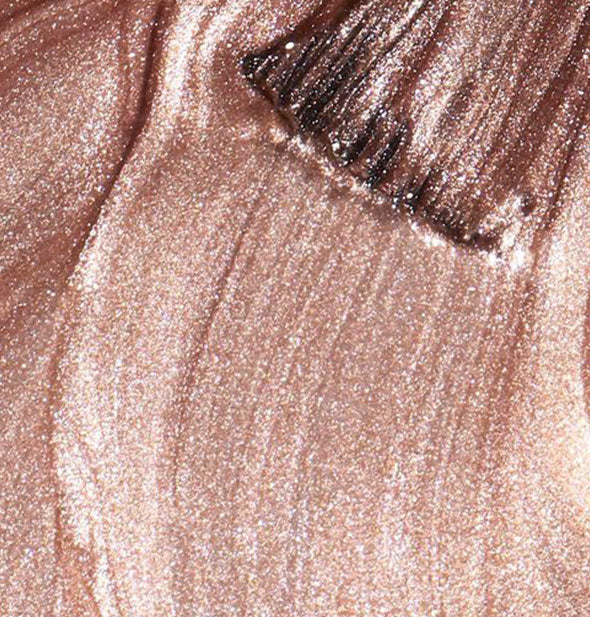 Shimmery rose gold nail polish with brush tip streaked through