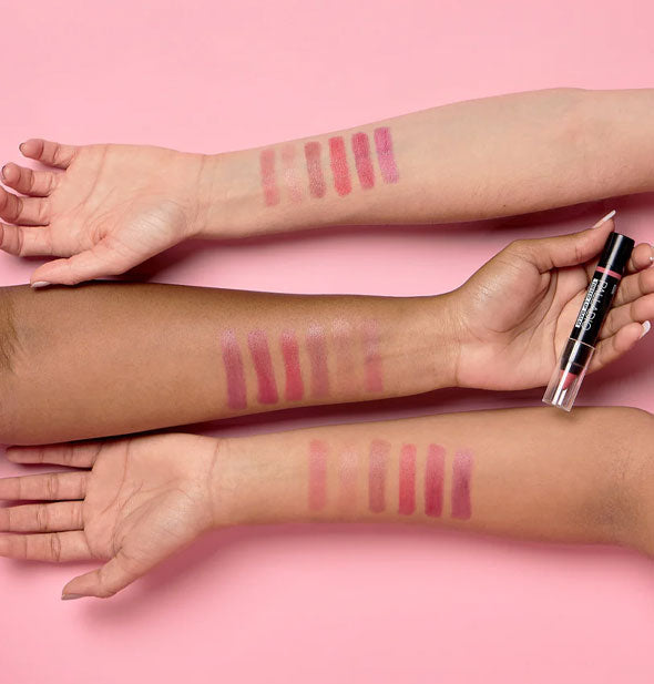 Three models' arms with sample applications of each Palladio Tinted Lip Balm shade drawn on to show how each color appears on different skin tones