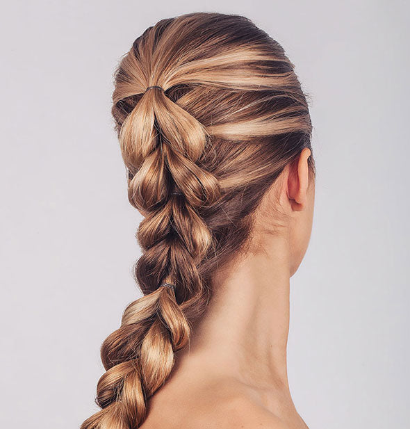 Model wears hair in a dramatic fishtail French braid