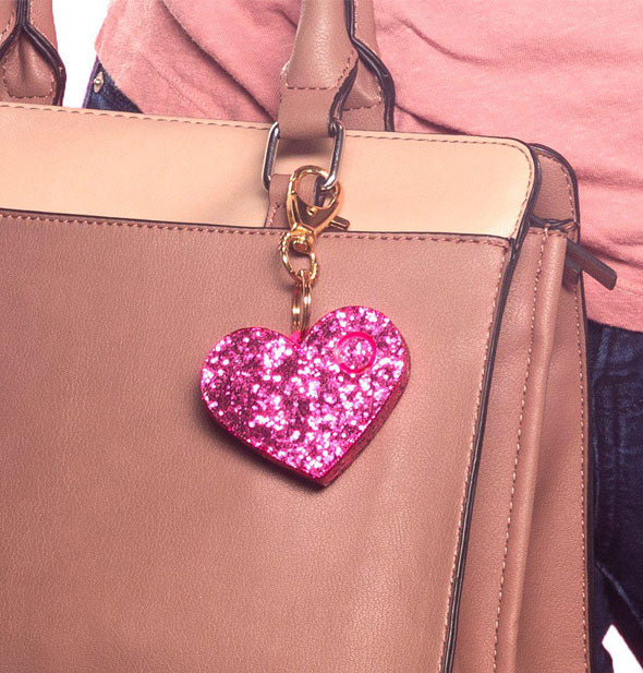 Purse with heart-shaped pink glitter personal alarm keychain attached  to strap
