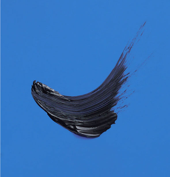 A sample swipe of black mascara on a blue surface