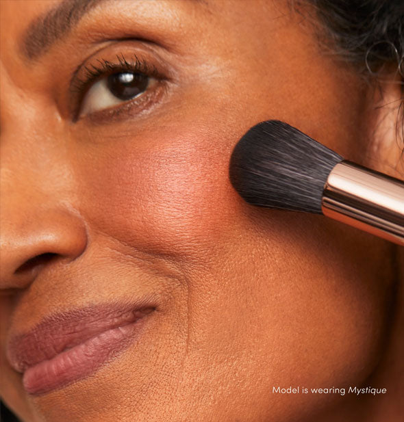 Model applies PurePressed Blush to cheek in the shade Mystique