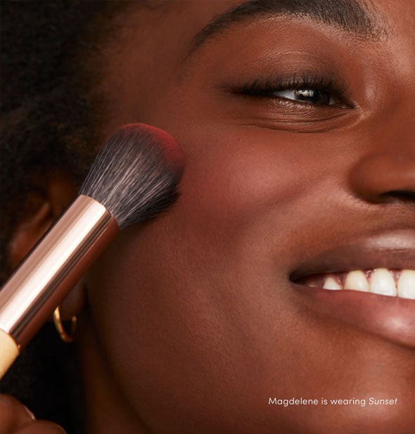 Model applies PurePressed Blush to cheek in the shade Sunset