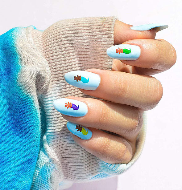 Model wears light blue nails with colorful graphic accents