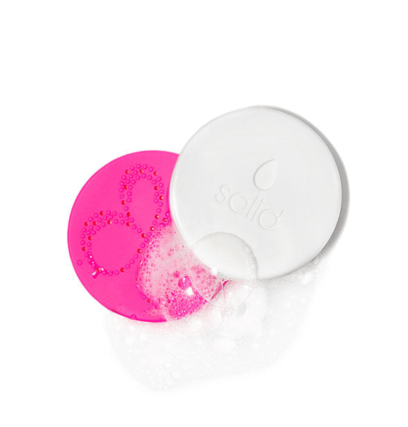 Solid makeup brush and sponge cleansing disc with textured pink pad